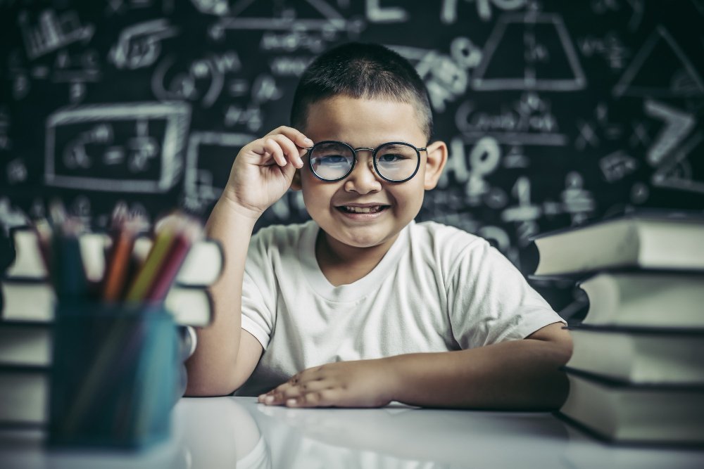 boy studying holding glasses leg classroom